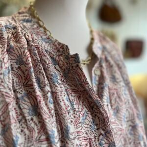 Cette chemise fluide allie élégance bohème et légèreté avec son imprimé fleuri délicat, son col en V fendu et ses manches. Polyvalente, elle se porte aussi bien avec un pantalon fluide et des escarpins pour un look chic, qu’avec un jean et des baskets pour un style décontracté, ou encore avec une jupe longue et des sandales pour une touche bohème.